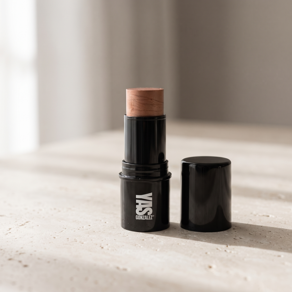 Highlighter Stick de YG Beauty sobre piedra caliza