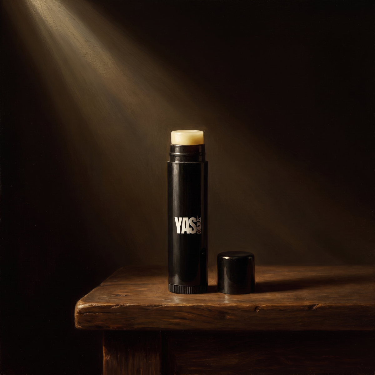 Vegan Lip Balm de YG Beauty sobre nogal oscuro, luz de claroscuro