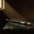 Lip Liner de YG Beauty sobre mármol verde oscuro, luz de claroscuro