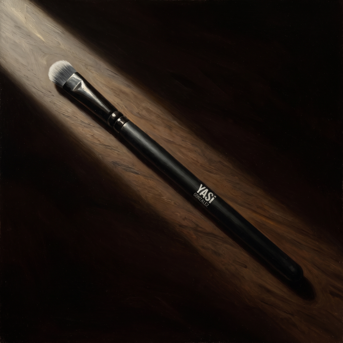 Packing Eye Brush de YG Beauty sobre nogal oscuro, luz de claroscuro